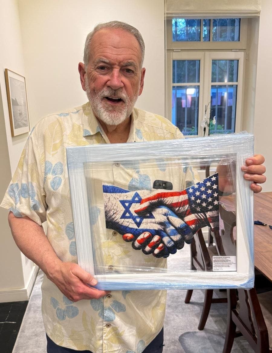 U.S. Ambassador Mike Huckabee holding the US-Israel handshake artwork from Kings Gallery